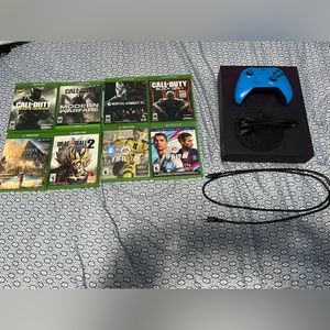 Purple Xbox One s with games, controller, and cables